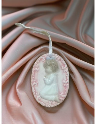 Medallón niña en oración en cerámica blanca y rosa – 5 × 7 cm