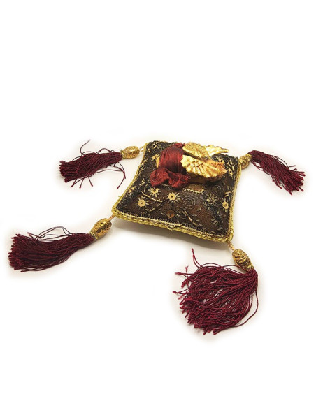 Sleeping terracotta angel on a handmade burgundy cushion